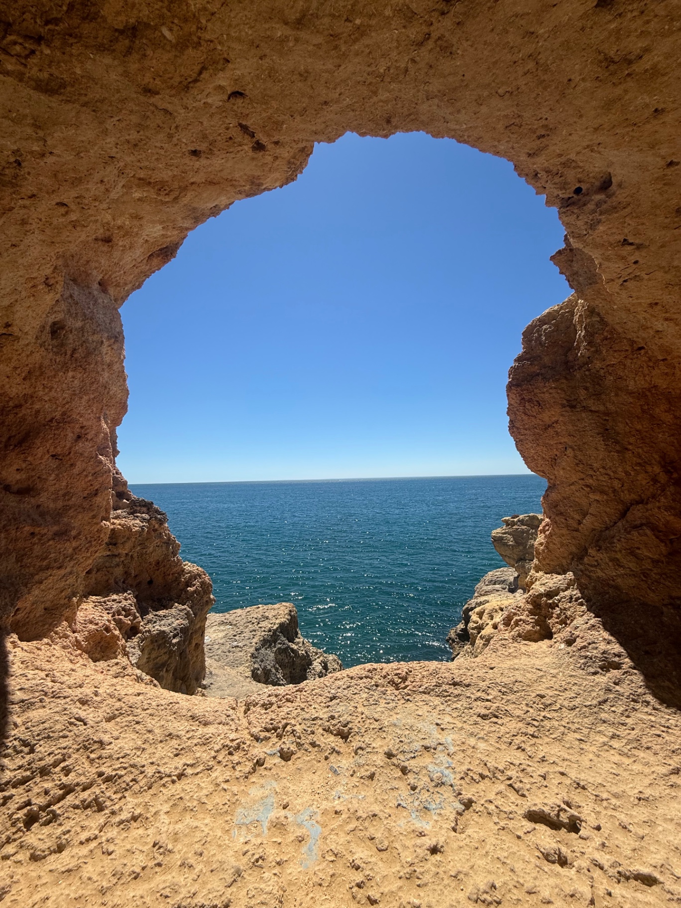 Sea view through a sandstone cave on the Algarve coast